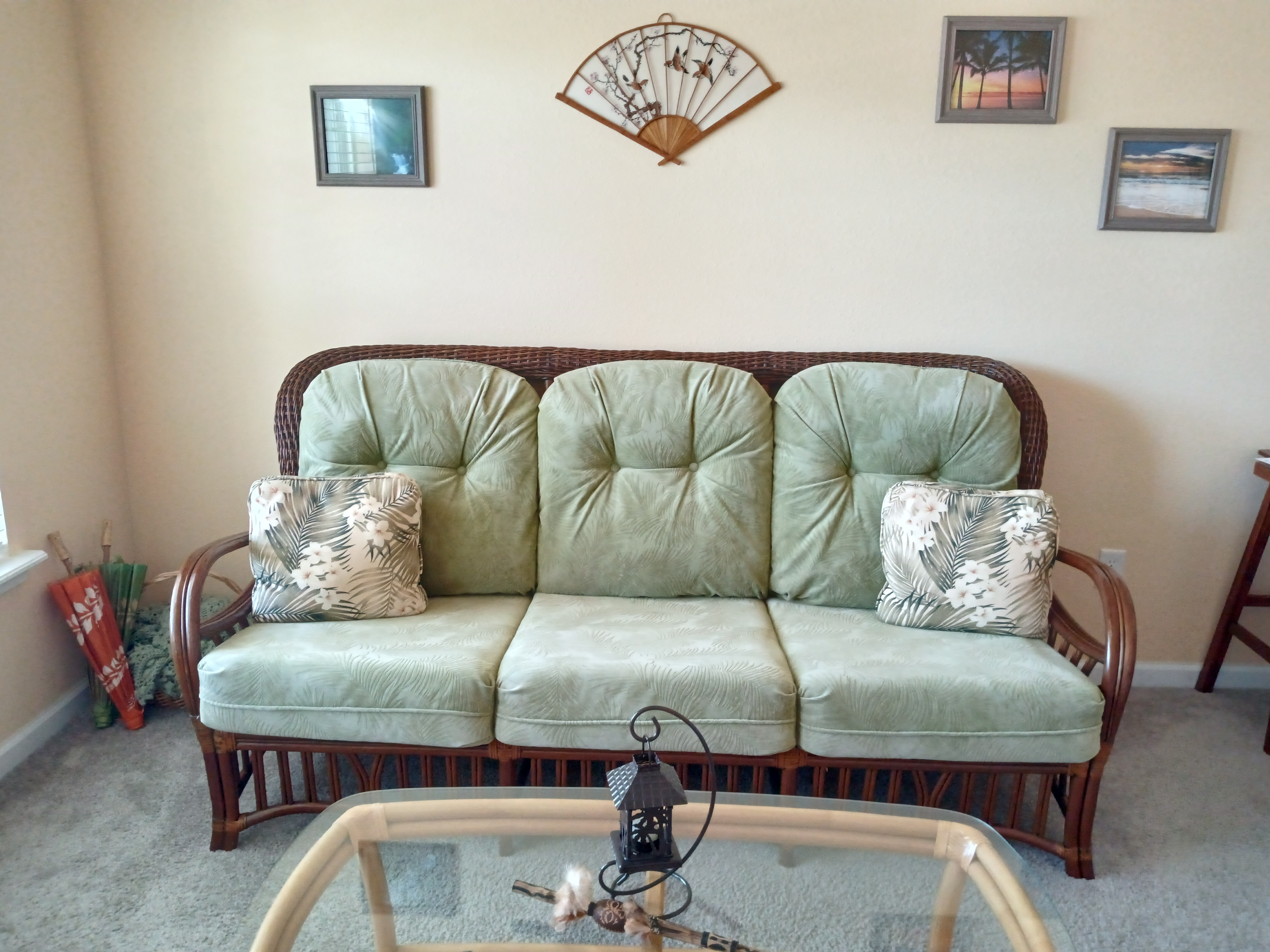 Rattan sofa set with coastal art and fan wall decor